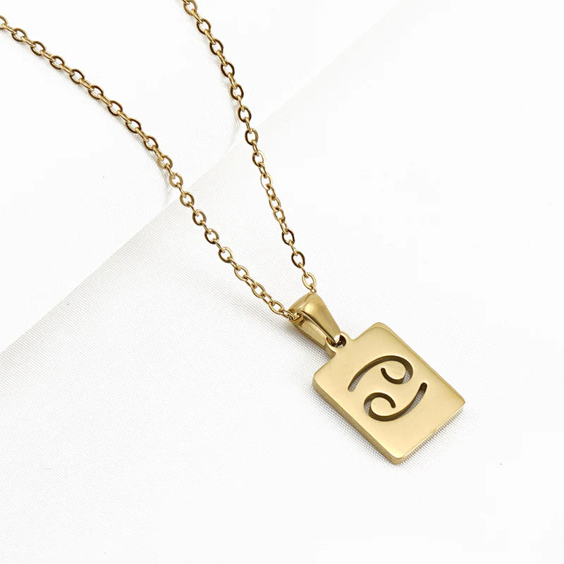 A gold necklace with a dainty chain and rectangular pendant in the Cancer style. 