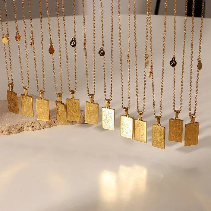 18k gold necklaces hanging. The necklaces have a square pendant with etching representative of one of the 12 zodiac signs. Each necklace also has a small charm with the complementary zodiac symbol. 