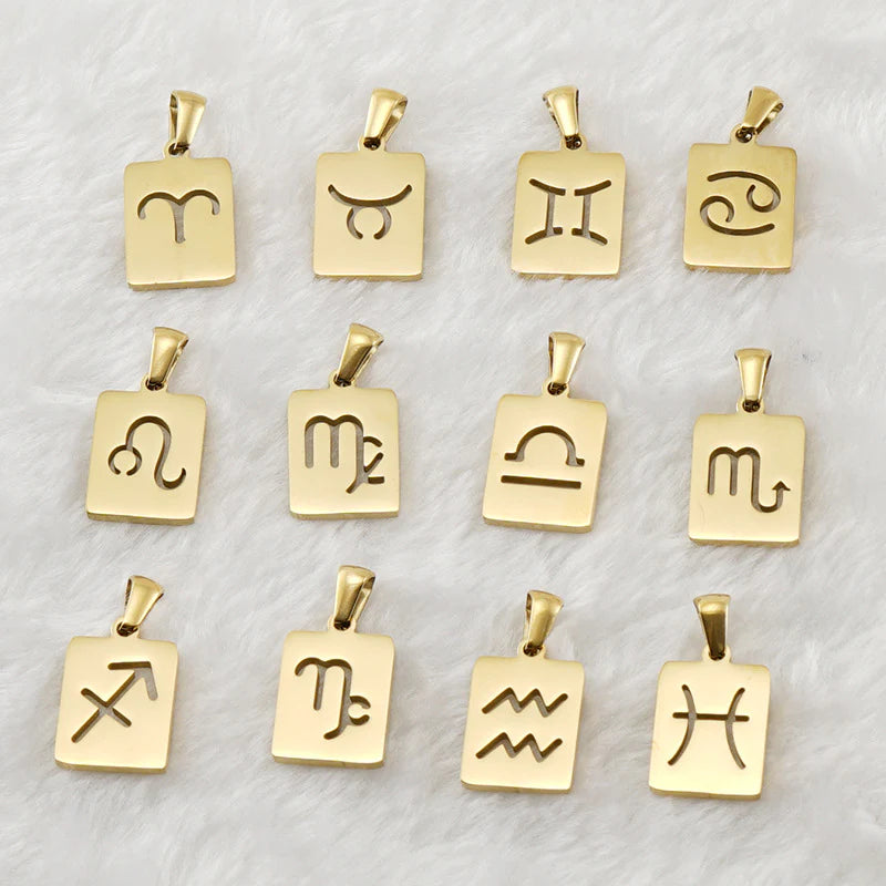 The pendants, without the chains, lying against a fluffy white background. The pendants ae in order of the astrological ecliptic.