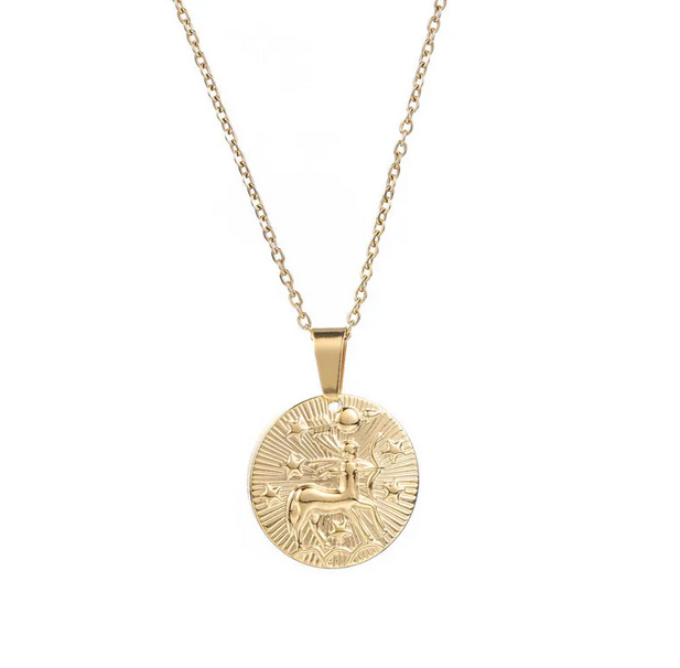 A gold necklace with a dainty chain. The necklace has a coin pendant displaying the astrological sign Sagittarius of the zodiac.