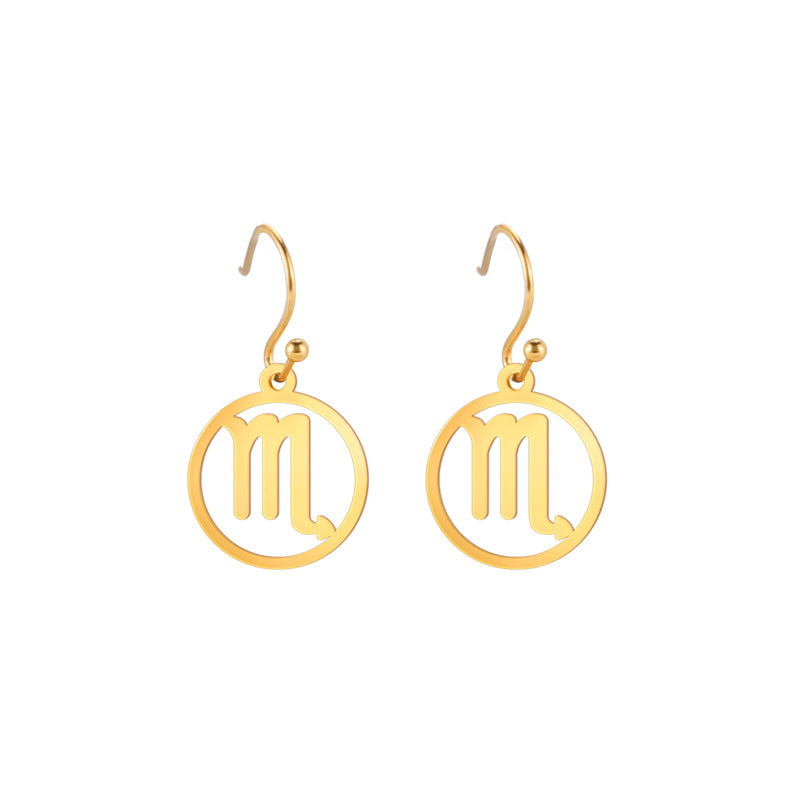 Gold earrings with the astrological symbol for Scorpio. The zodiac earrings are suspended in the air with a white background.