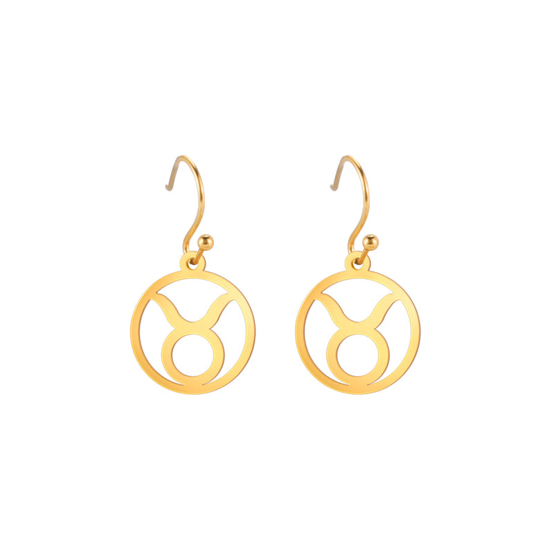 Gold earrings with the astrological symbol for Taurus. The zodiac earrings are suspended in the air with a white background.