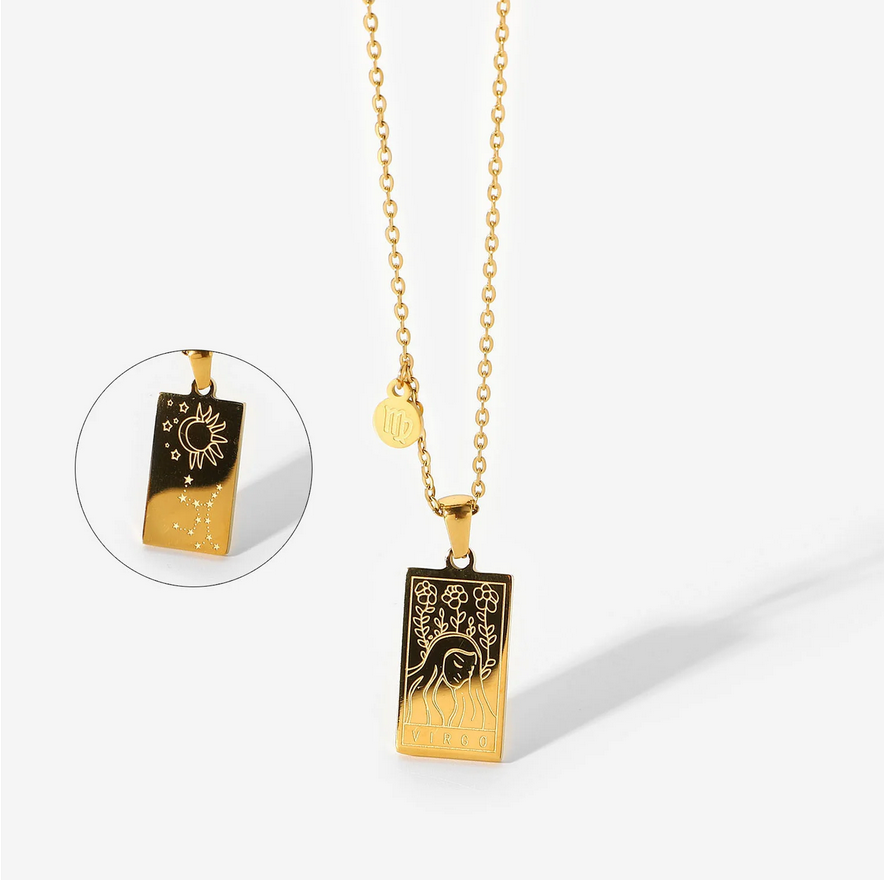 A gold necklace with a dainty chain. The necklace has a two-sided pendant in the Virgo style. The front side displays the animal which represents the zodiac in laser etching with the sign spelled out in capital letters. The reverse is shown as a picture in picture image. The reverse is in the style of the astrological constellation. There is also a small circular charm with the zodiac symbol approximately one inch above the pendant.